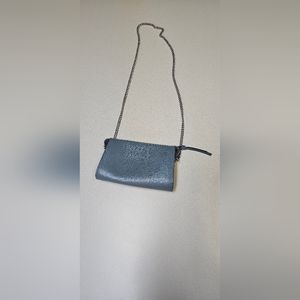 Women blue purse with silver chained straps. Used with a black spot inside.